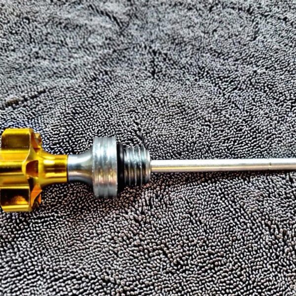 TAPON MEDIDOR DE ACEITE LARGO DORADO